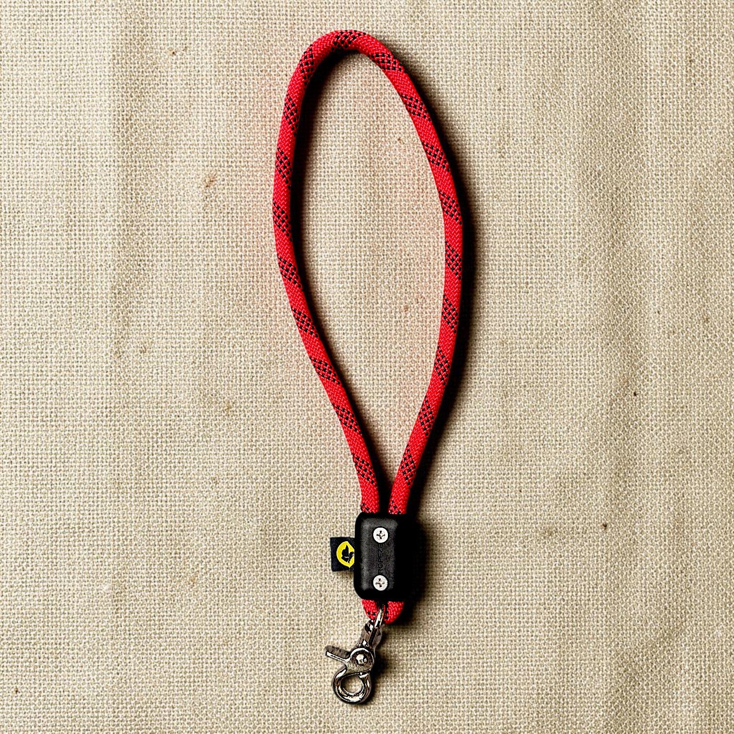 Red traffic handle short dog leash with a stainless steel clip on a burlap cloth